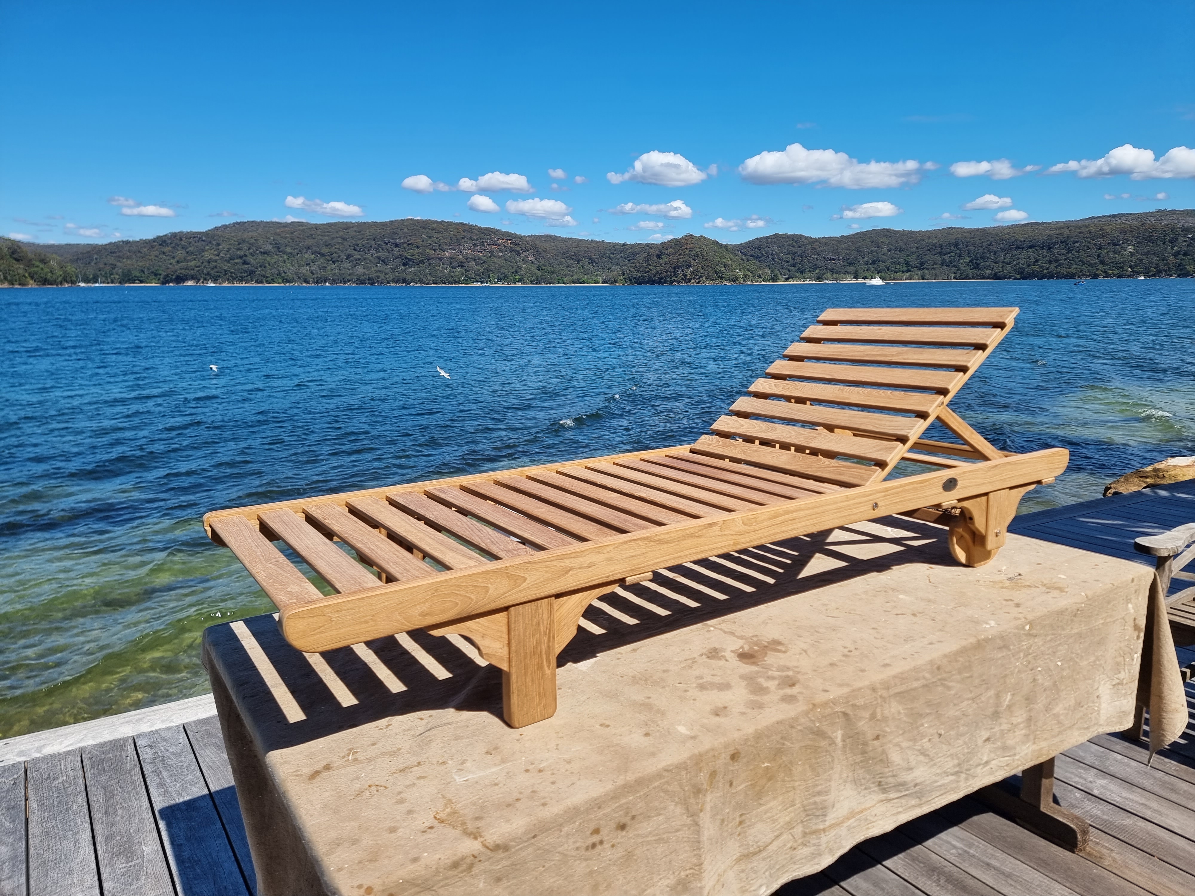 Freshly oiled timber sun lounger on waterfront dock — Pittwater