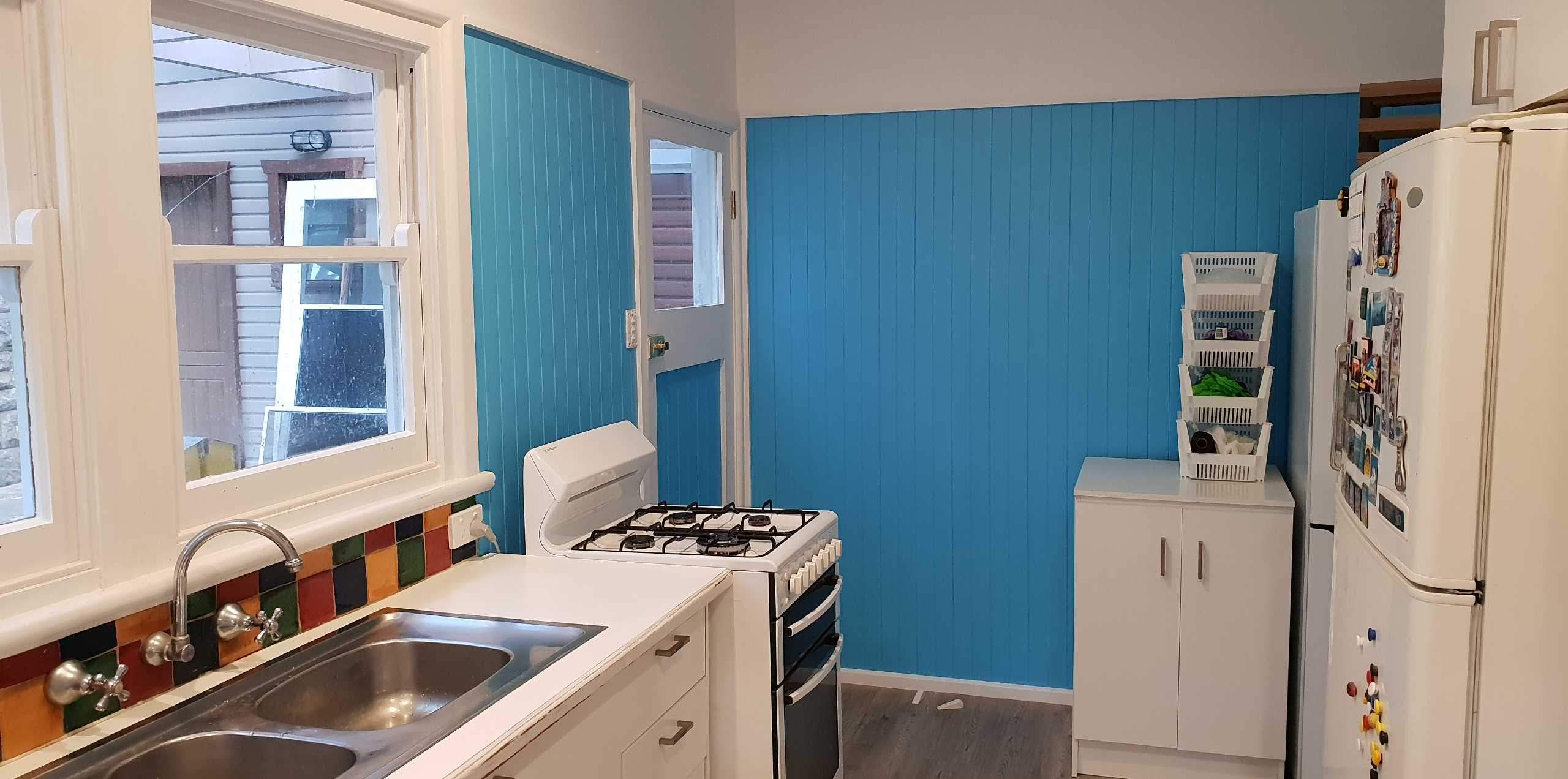 Interior painting — fresh blue wall with white trims and window frames