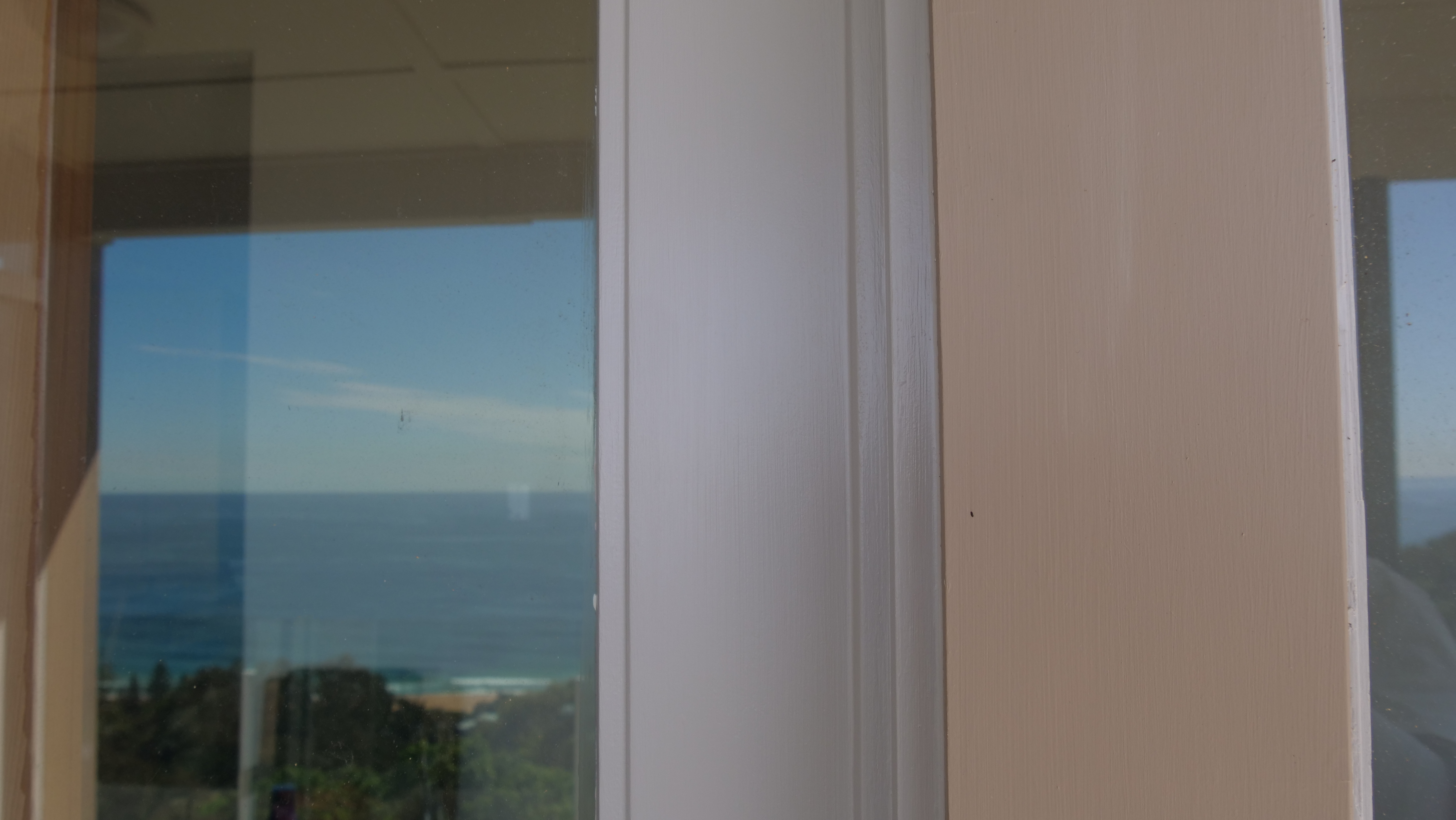 White gloss window frames and trims with ocean view — stain to gloss conversion